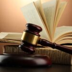 Wooden,Gavel,And,Books,On,Wooden,Table,on,Brown,Background