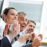 Group,Of,Cheerful,Businesspeople,Sitting,In,A,Row,On,A