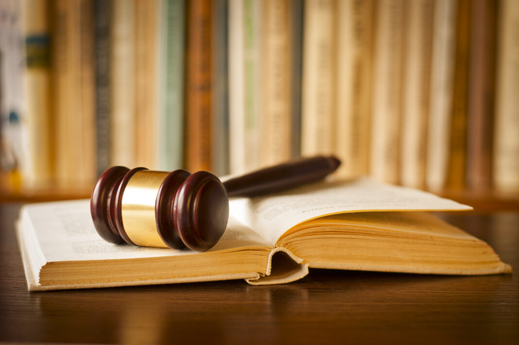Open,Law,Book,With,A,Judges,Gavel,Resting,On,Top